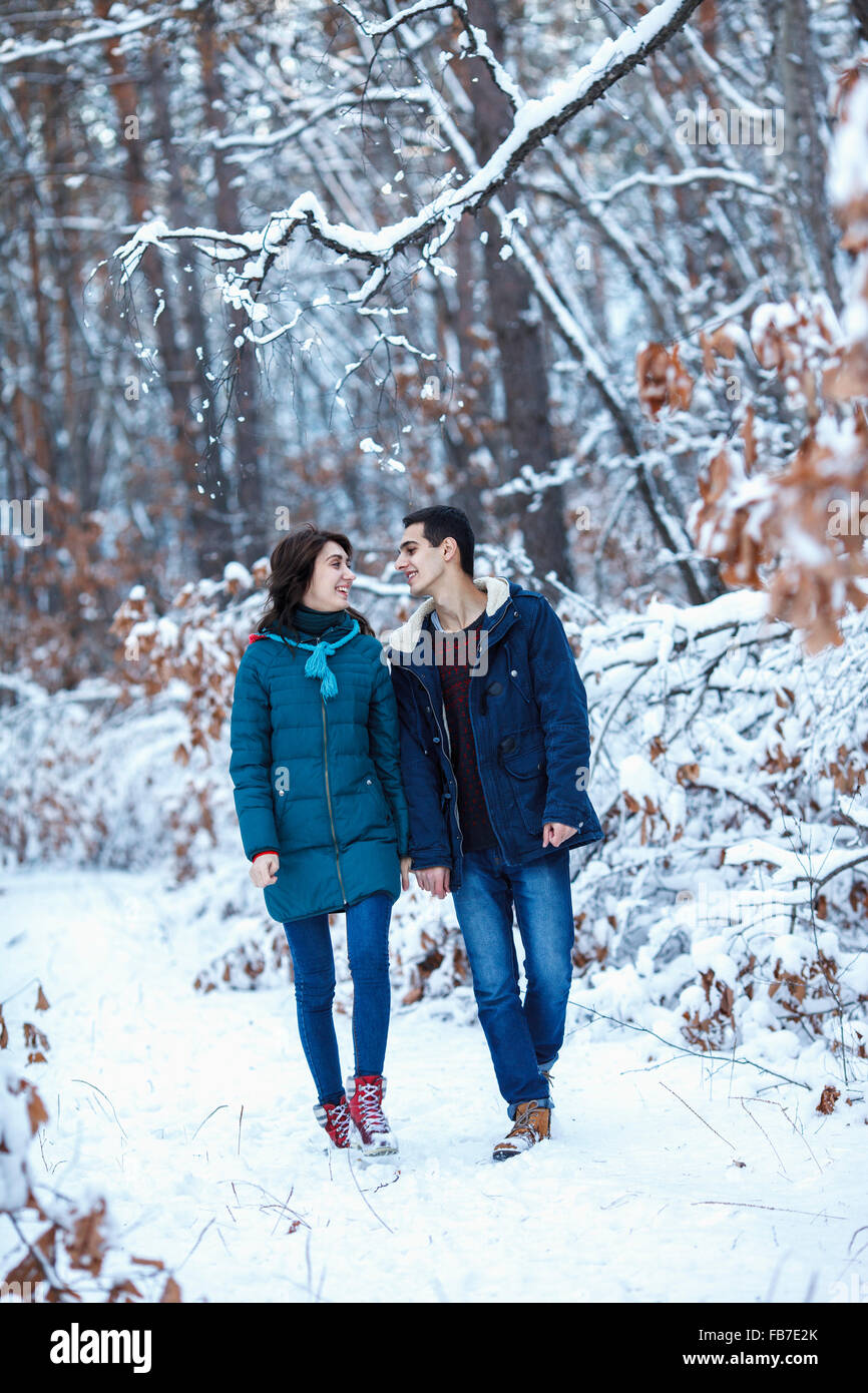 Full length of loving young couple in warm clothing walking on snowy field Stock Photo