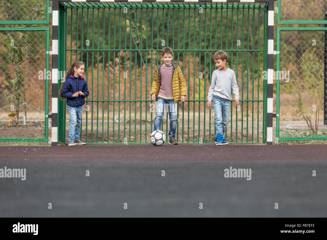 Children playing soccer at playground Stock Photo