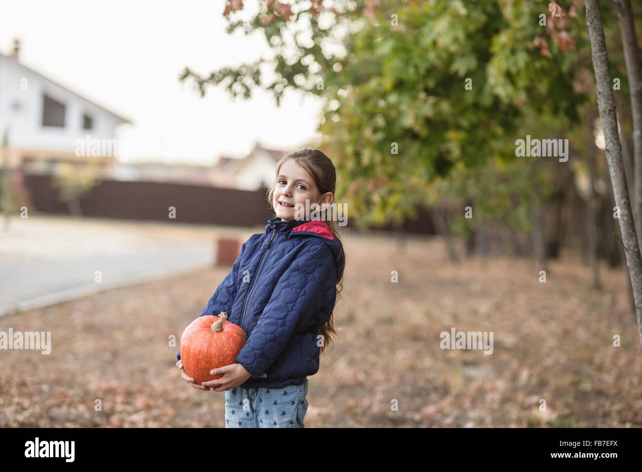 Portrait of cute girl holding pumpkin outdoors Stock Photo - Alamy