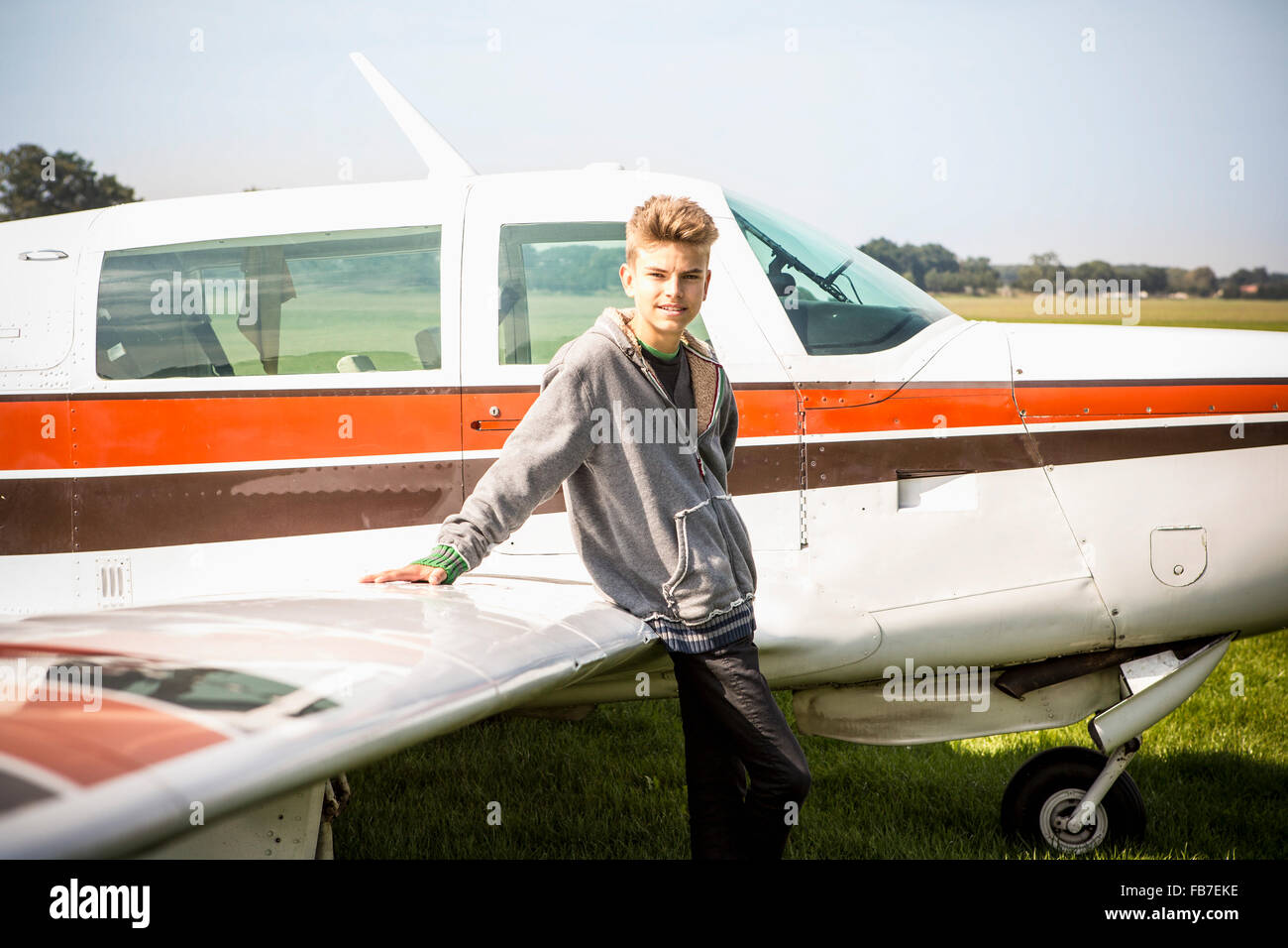 Portrait of teenage boy leaning on private airplane Stock Photo