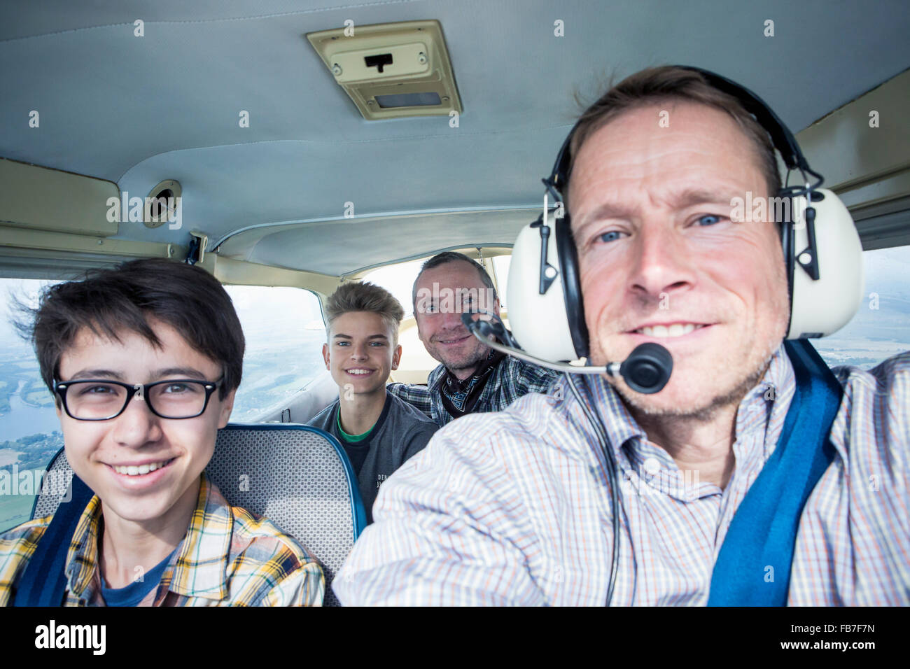 Portrait of men and teenage boys in private airplane Stock Photo