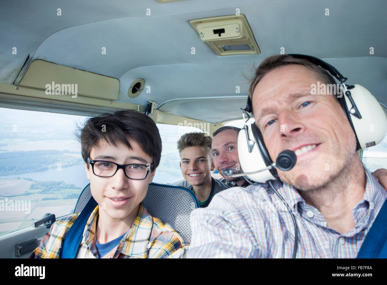 Portrait of men and teenage boys sitting in private airplane Stock Photo
