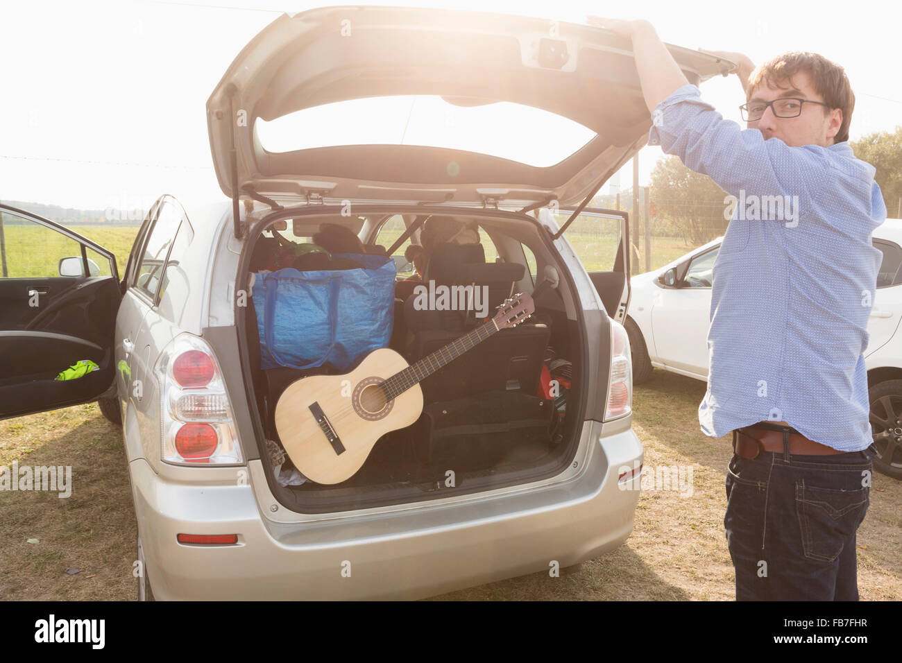 Side view of man closing car trunk Stock Photo