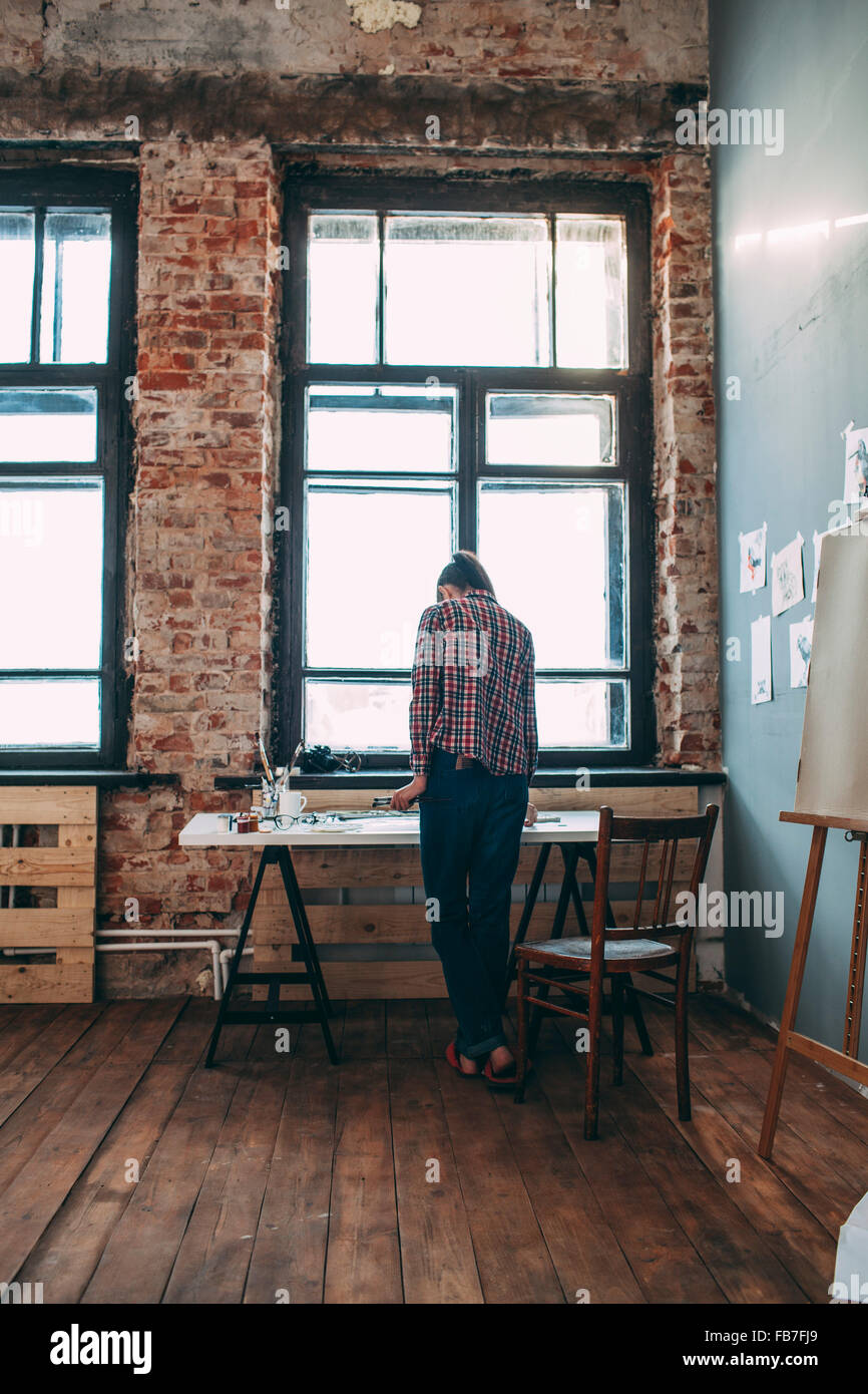 Rear view of artist standing in art studio Stock Photo - Alamy