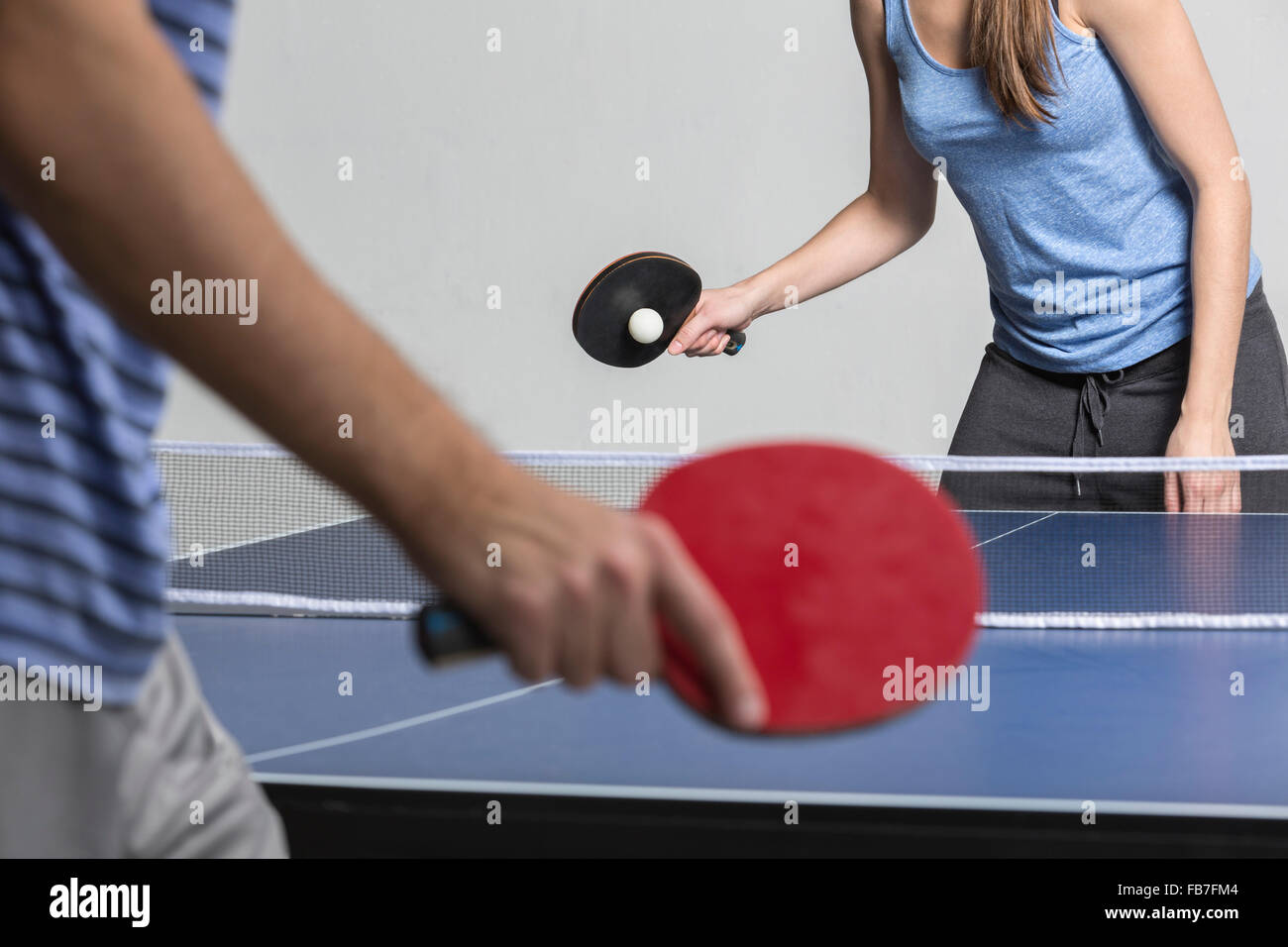 Midsection of man and woman playing table tennis Stock Photo