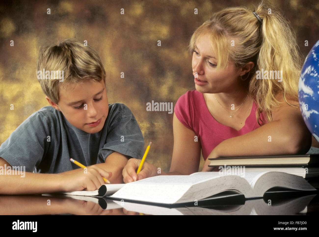 older sister helping younger brother study Stock Photo