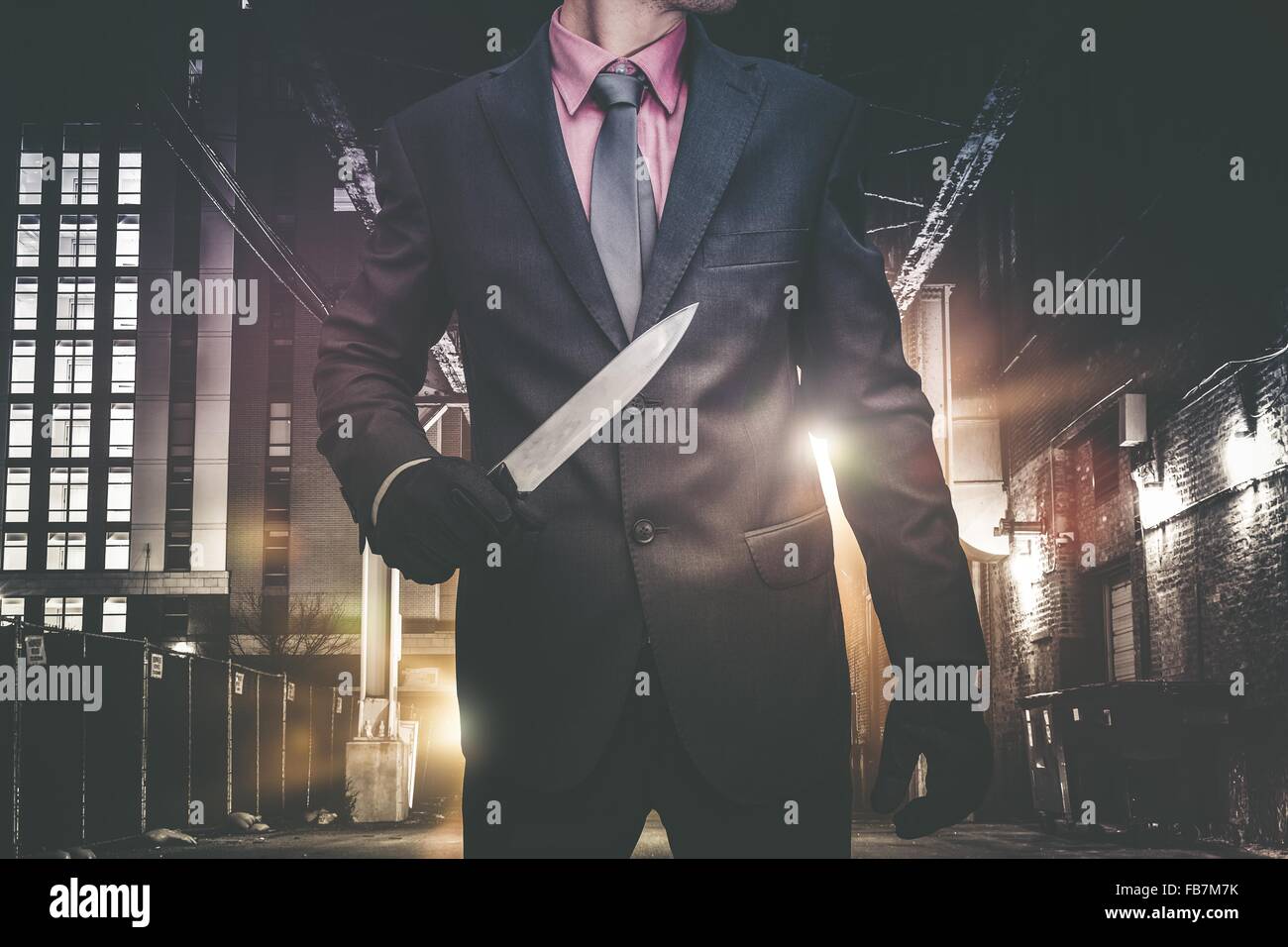 Psychopathic Downtown Murderer Walking Through the Alley with Huge Knife. Wearing Elegant Suit and Tie. Urban Crime Concept. Stock Photo