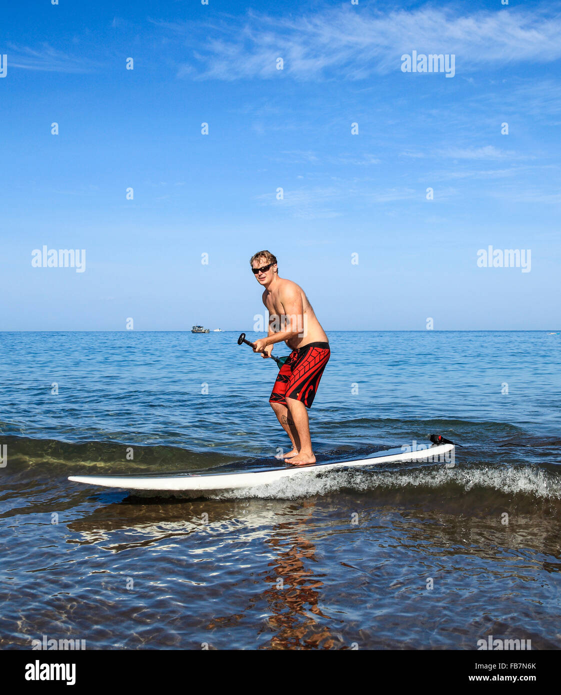 Man enjoys stand up paddle surfing at Wailea Beach on Maui Stock Photo
