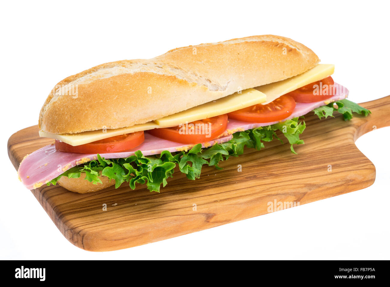 A fresh ham, cheese and salad sandwich in a crusty bread roll on a wooden chopping board - studio shot with a white background Stock Photo