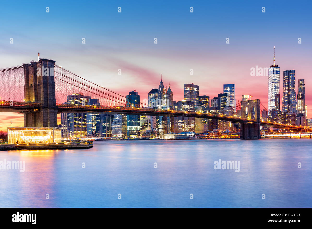 Brooklyn Bridge and the Lower Manhattan skyline under a purple sunset Stock Photo