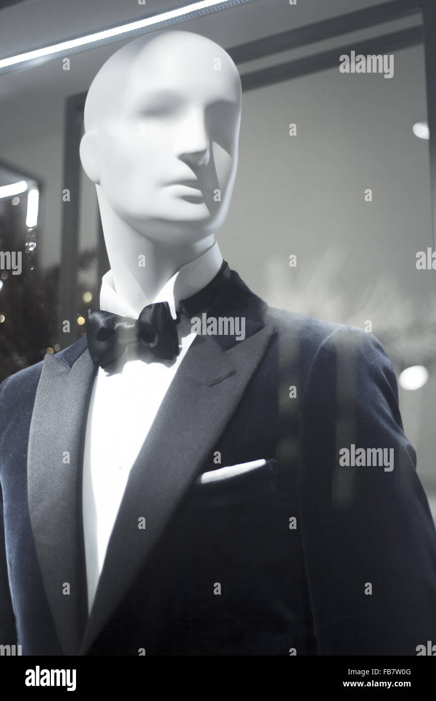 Shop dummy fashion mannequin in department store boutique window wearing evening suit dinner