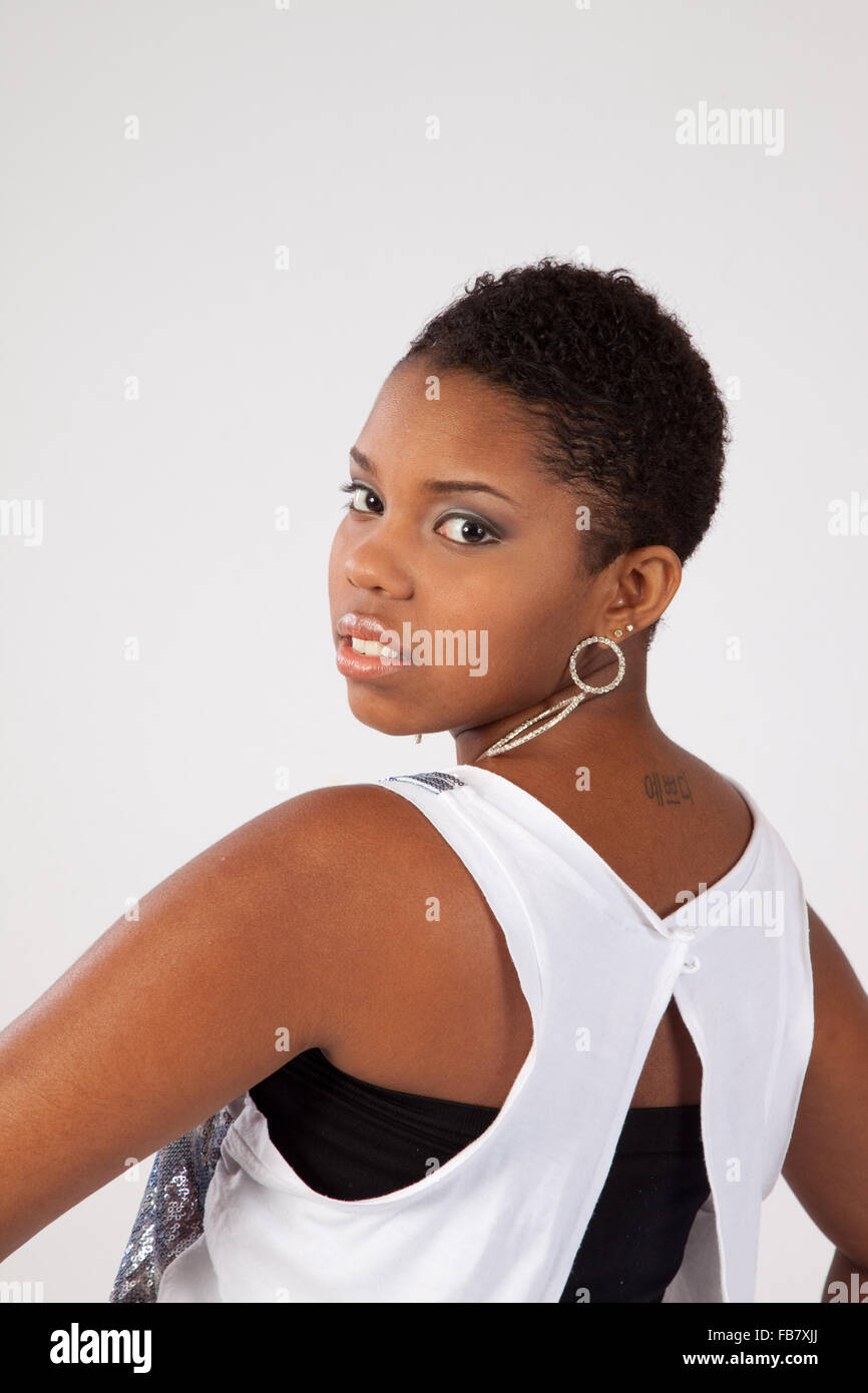 Lovely Black woman looking thoughtfully at the camera over her shoulder ...