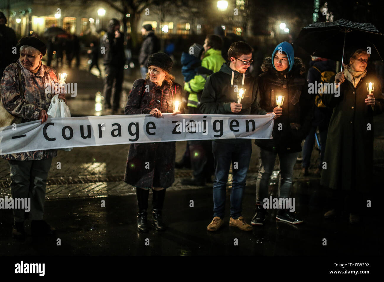 (160112)-- LEIPZIG, Jan. 12, 2016(Xinhua)-- People holding candles and a banner saying 'show courage' attend a rally, in Leipzig, Germany, on Jan. 11, 2016. Forming a 'chain of lights' kilometers in length, thousands of people have participated in a rally against the anti-Islam movement Legida in the east German city of Leipzig on Monday evening. (Xinhua/Zhang Fan)(azp) Stock Photo