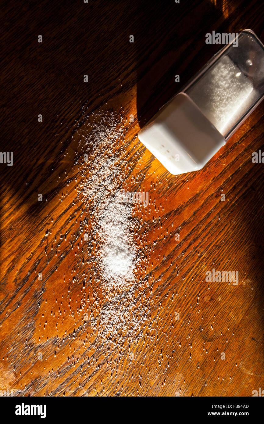 Spilled salt on a wooden desk Stock Photo