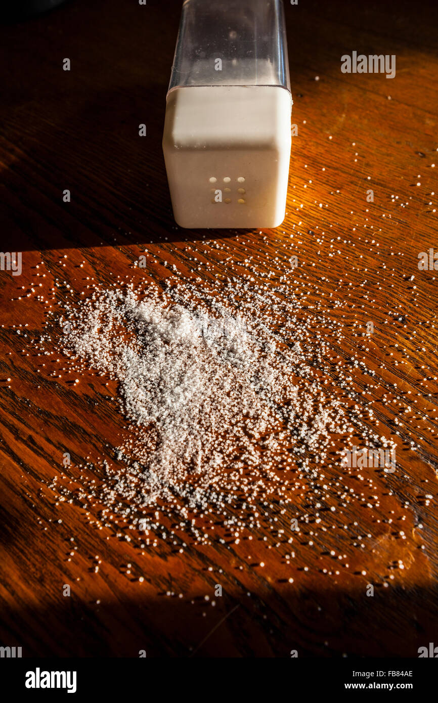 Spilled salt on a wooden desk Stock Photo