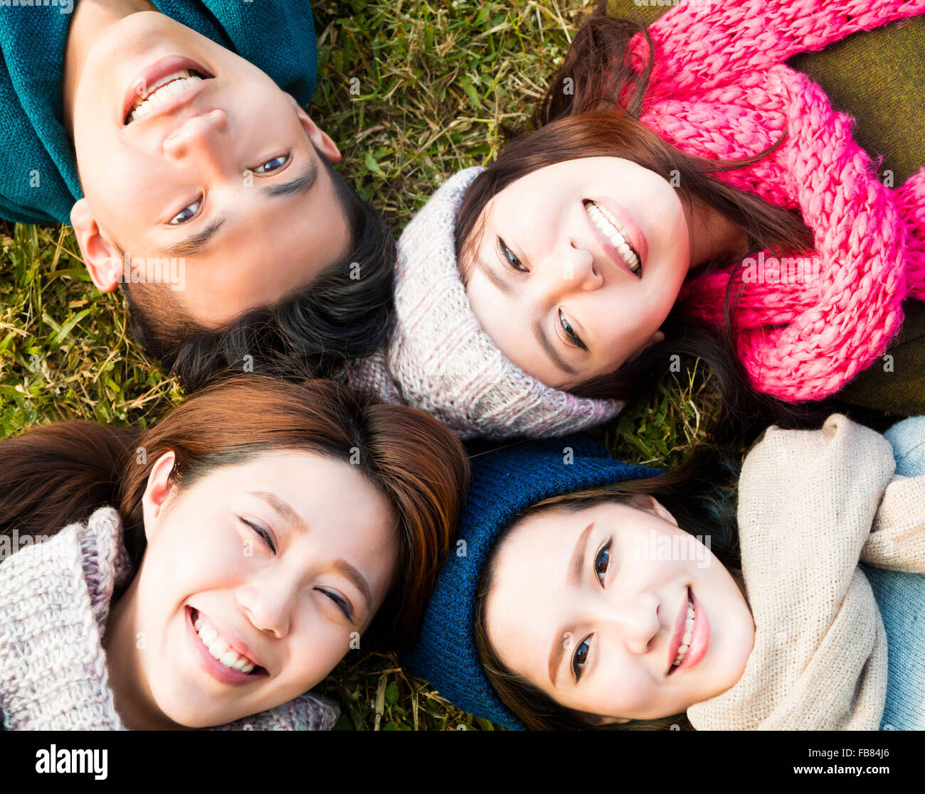 happy young group with winter wear on the grass Stock Photo
