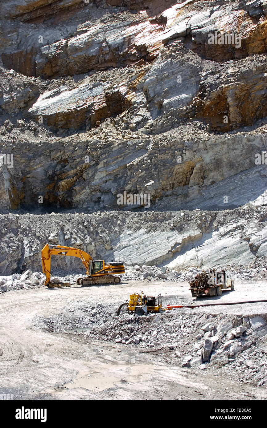 Stone is blasted from a rock quarry and is ready for transport for further processing at the top of the pit. Stock Photo