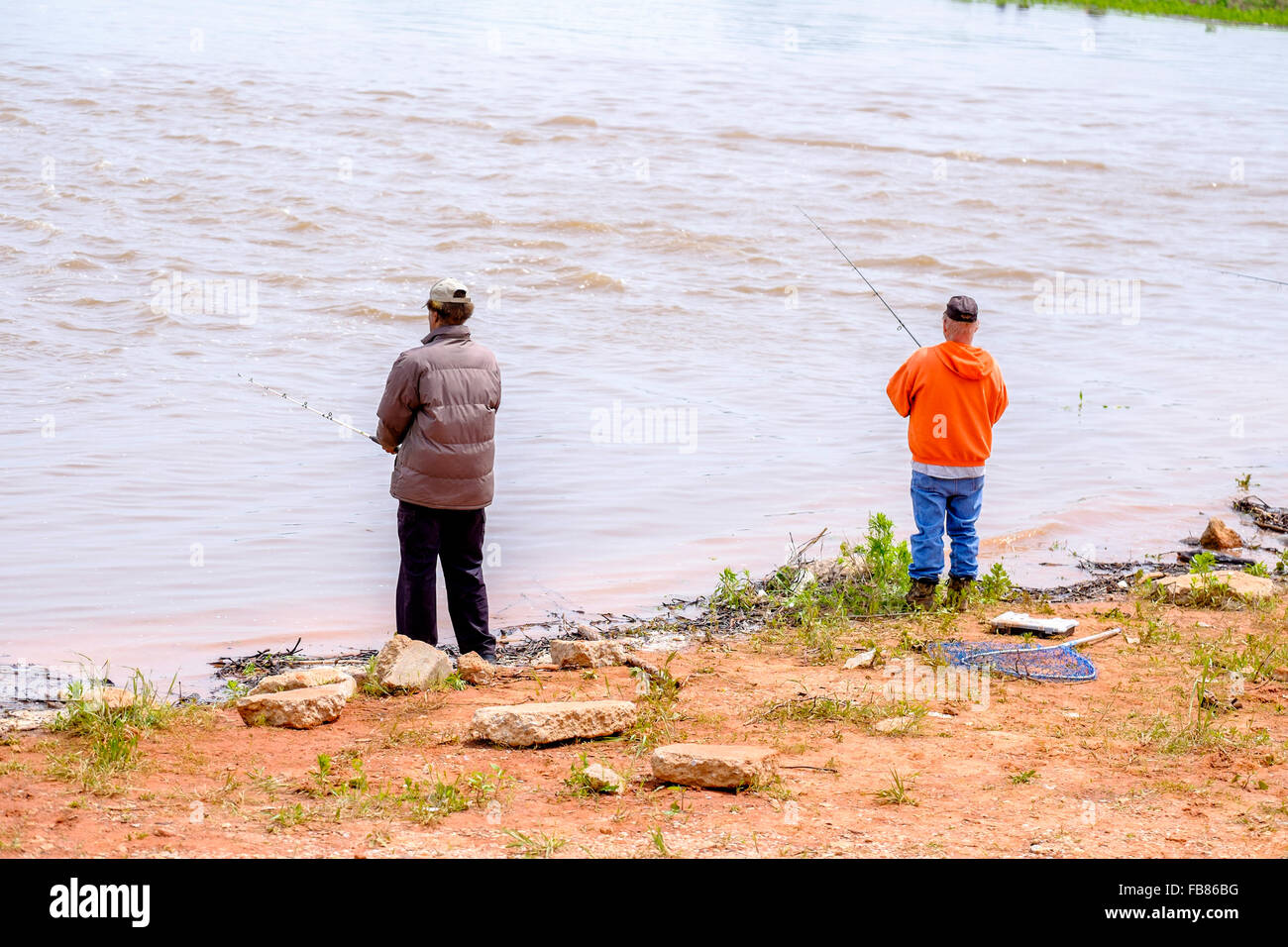 Two men fish in the rising waters of Hefner Lake in Oklahoma City after a spring rain. Oklahoma, USA. Stock Photo
