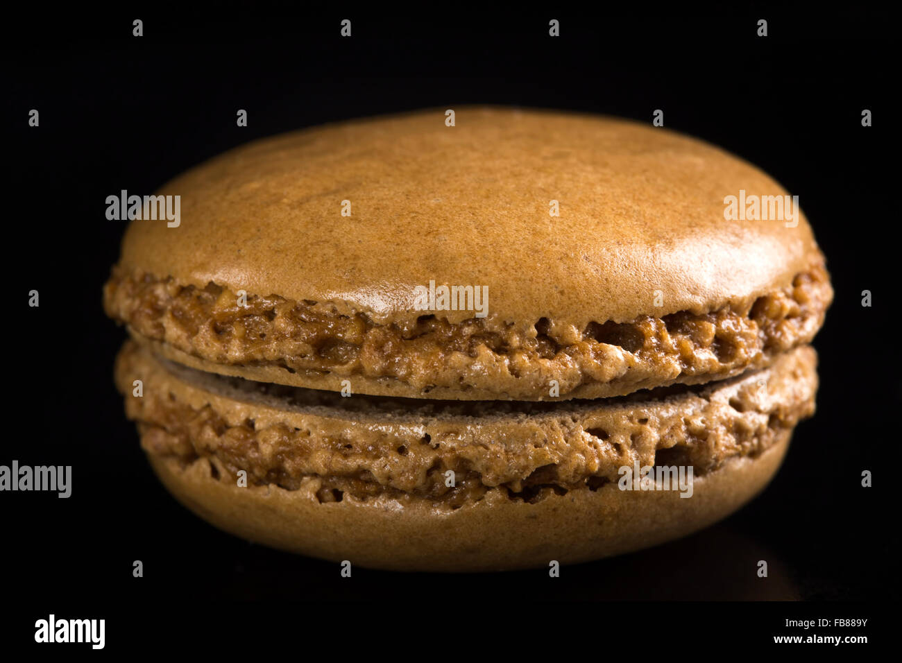 One chocolate macaroon on a black background Stock Photo
