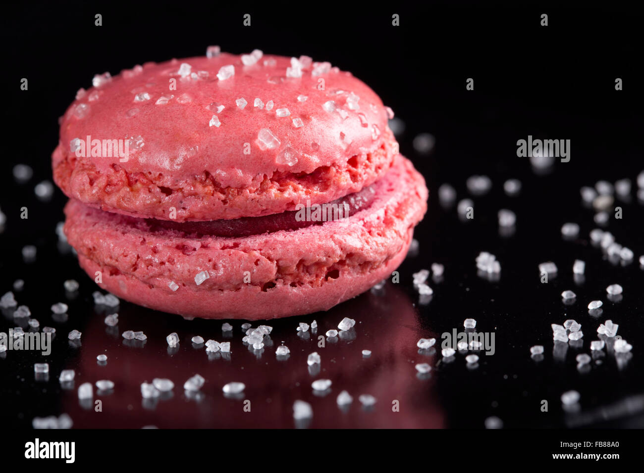 Pink macaroon cake an sugar over black background Stock Photo