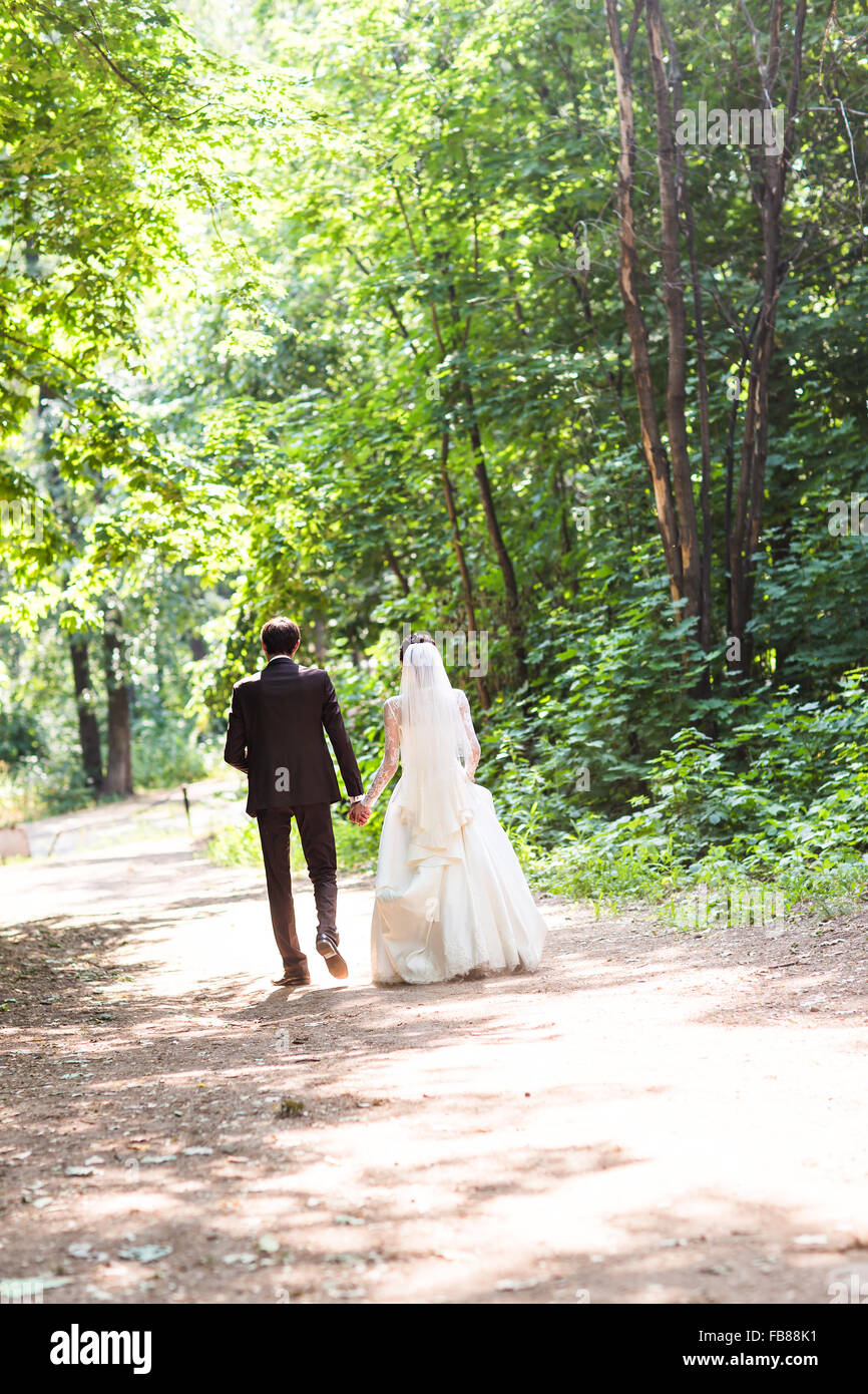 Back view of holding hands bride and groom Stock Photo - Alamy