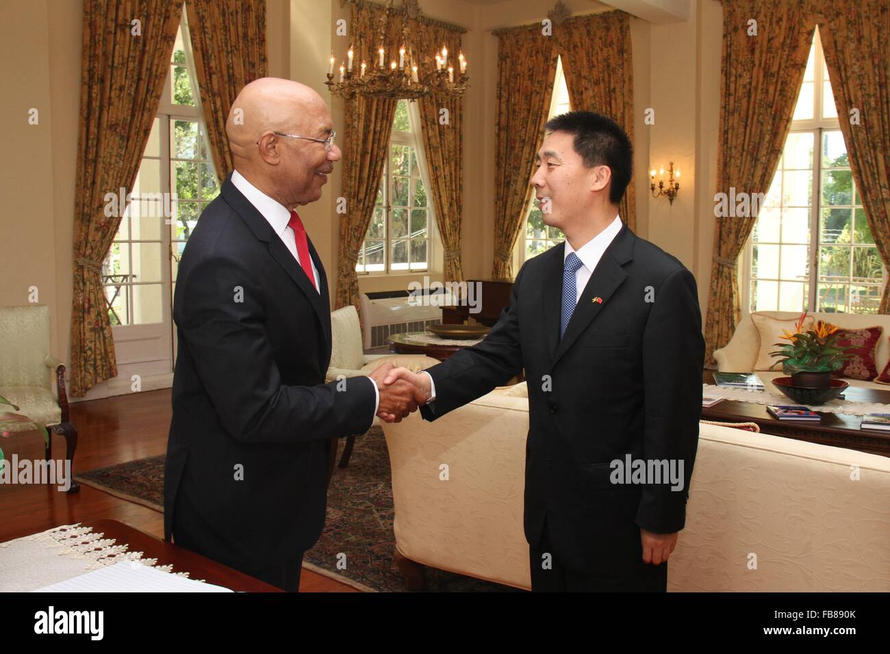 (160112)-- KINGSTON, Jan. 12 (Xinhua) -- Jamaican Governor General Patrick Allen (L) shakes hands with new Chinese Ambassador to Jamaica Niu Qingbao at King's House in Kingston, Jamaica, on Jan. 11, 2016. Niu Qingbao presented his credentials to Jamaican Governor General Patrick Allen on Monday.(Xinhua/Zhu Qingxiang)(azp) Stock Photo