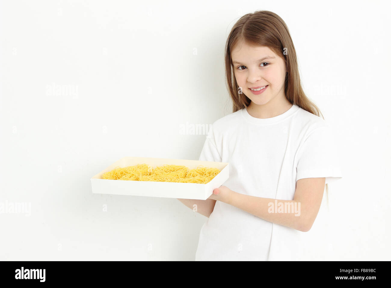 Joyful little girl holding pasta Stock Photo