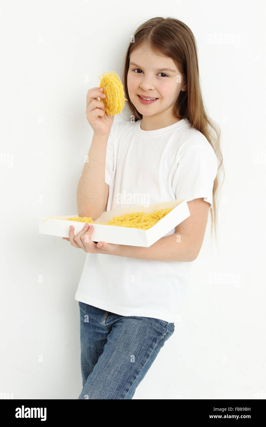 Joyful little girl holding pasta Stock Photo
