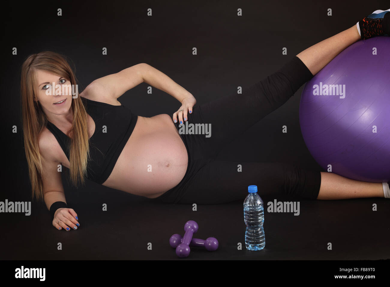 Pregnant woman stretches Stock Photo