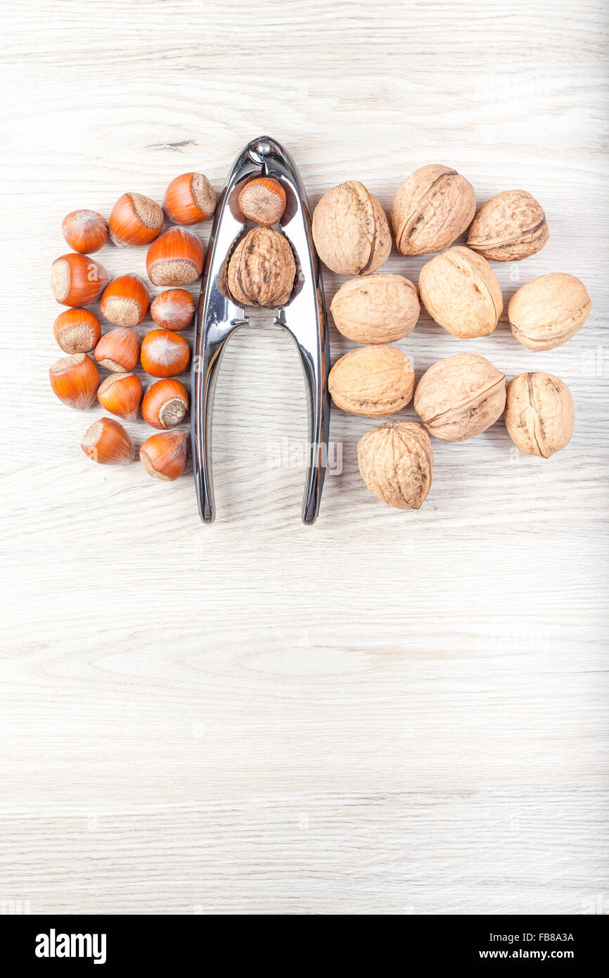 Nuts and nutcracker on wooden background, space for text. Stock Photo