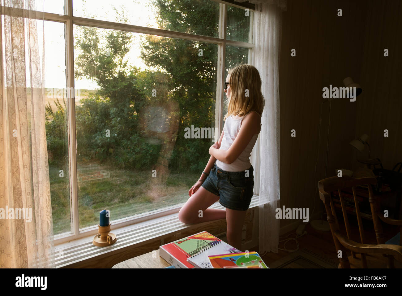Sweden, Skane, Vejbystrand, Girl (10-11) looking though window Stock Photo