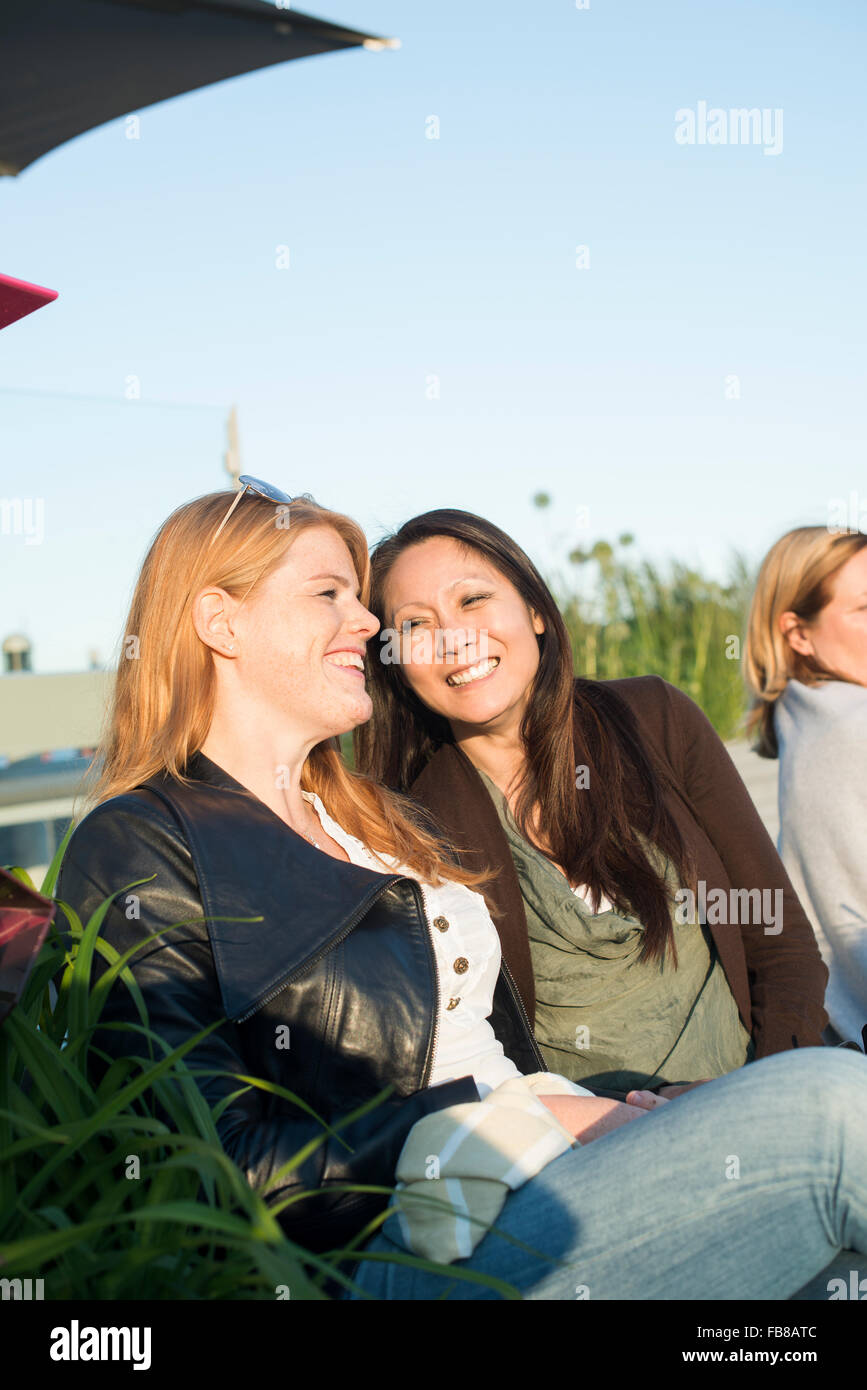Sweden, Uppland, Women talking on bench Stock Photo
