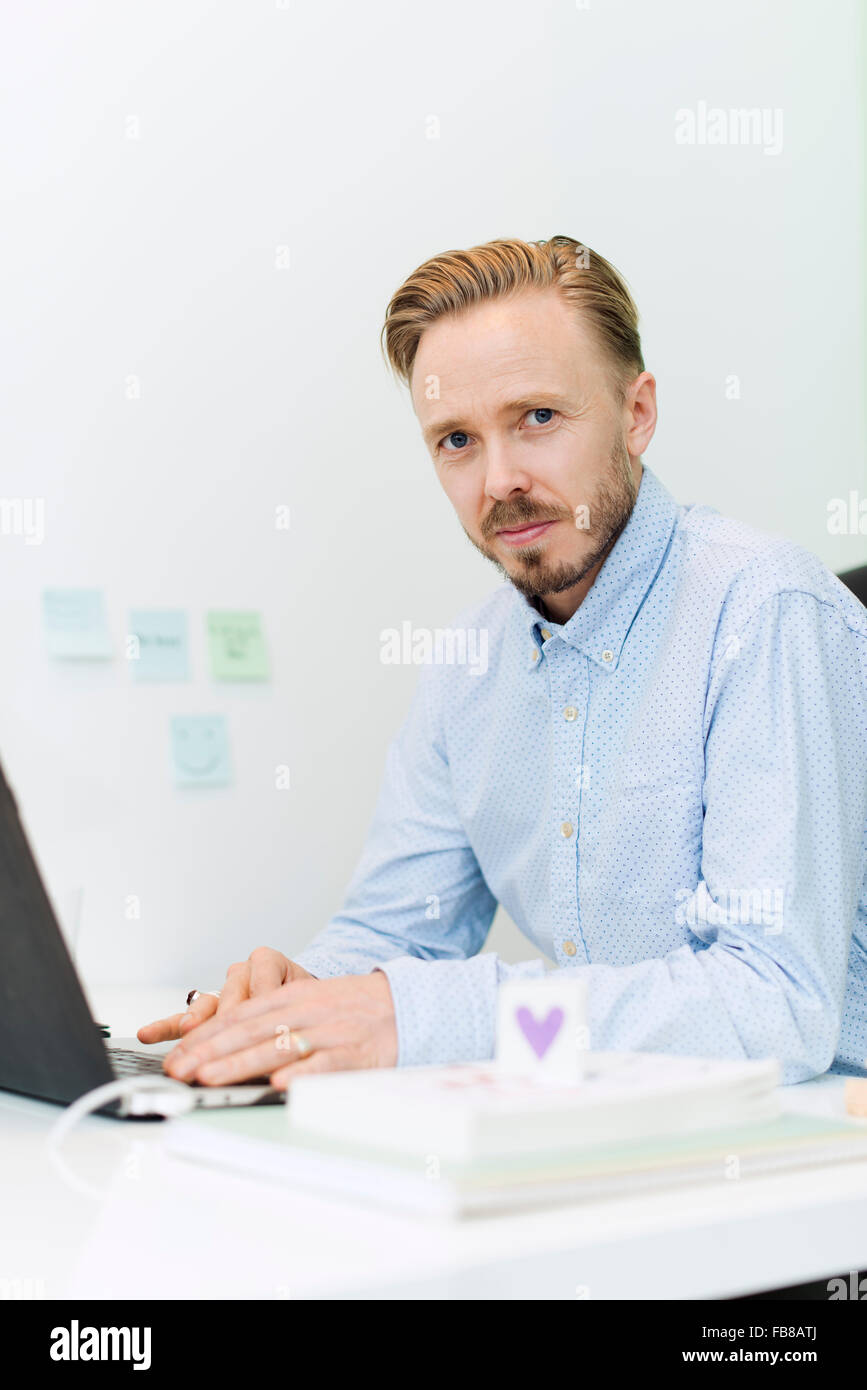 Sweden, Businessman working on laptop in office Stock Photo