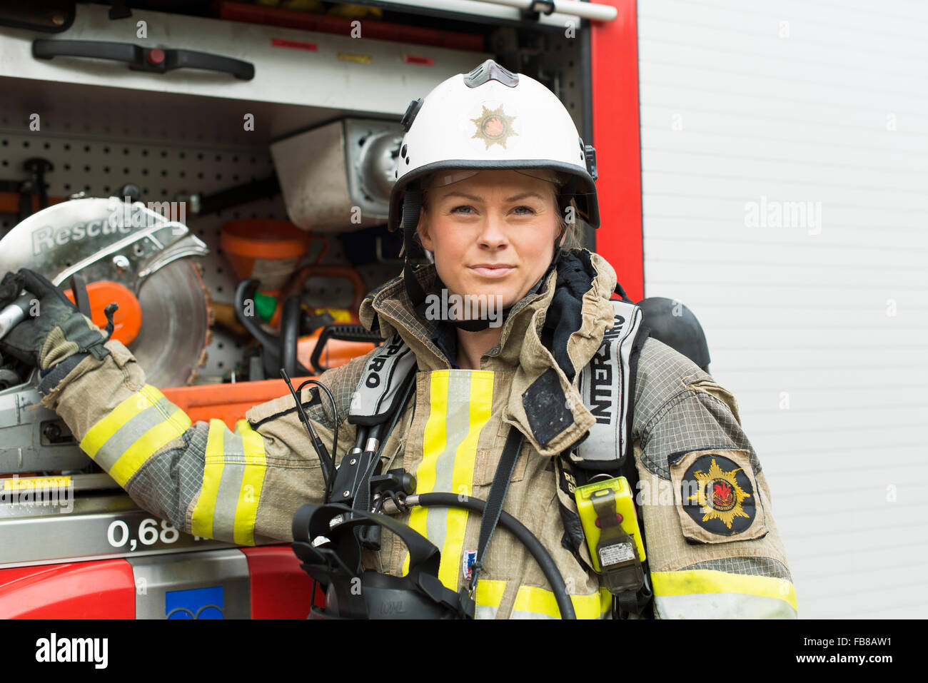 Sweden, Portrait of female firefighter by fire engine Stock Photo