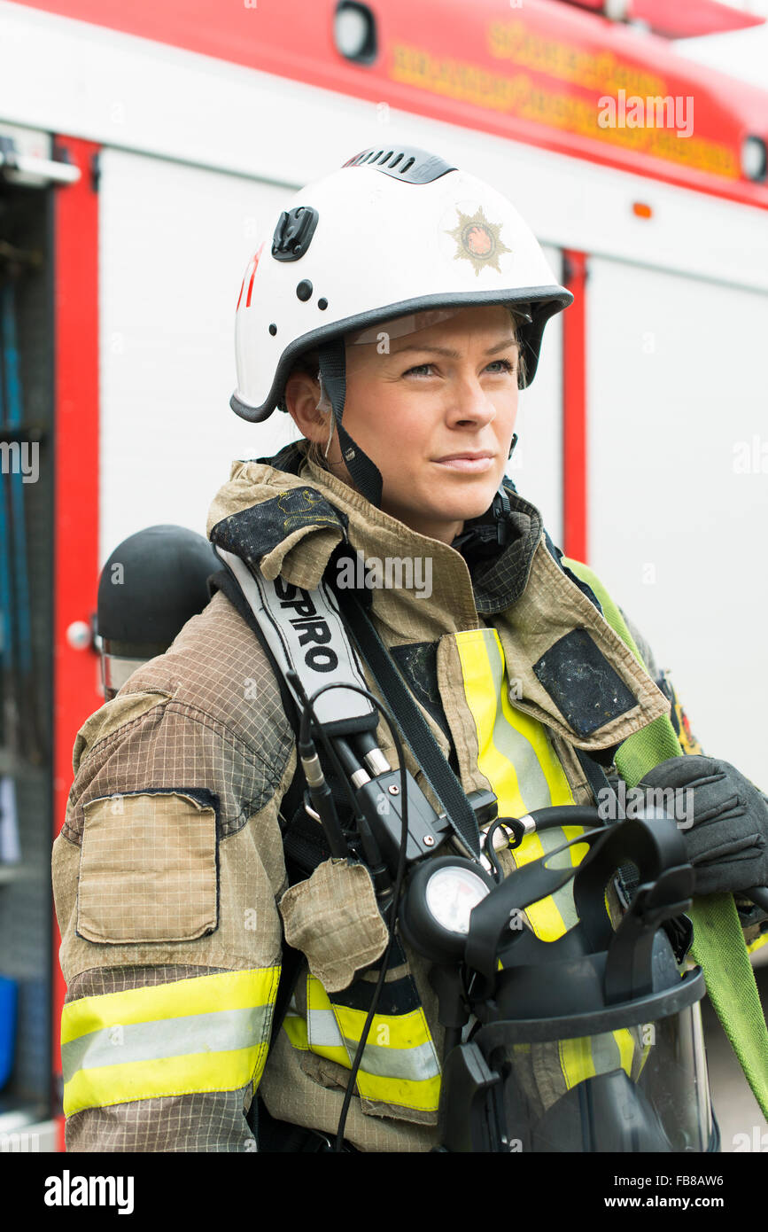 Sweden, Portrait of female firefighter with truck in background Stock Photo