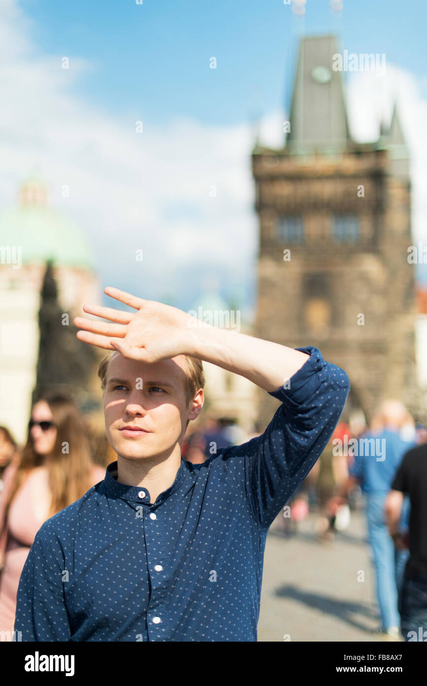 Sweden, Prague, Man shielding eyes on town square Stock Photo