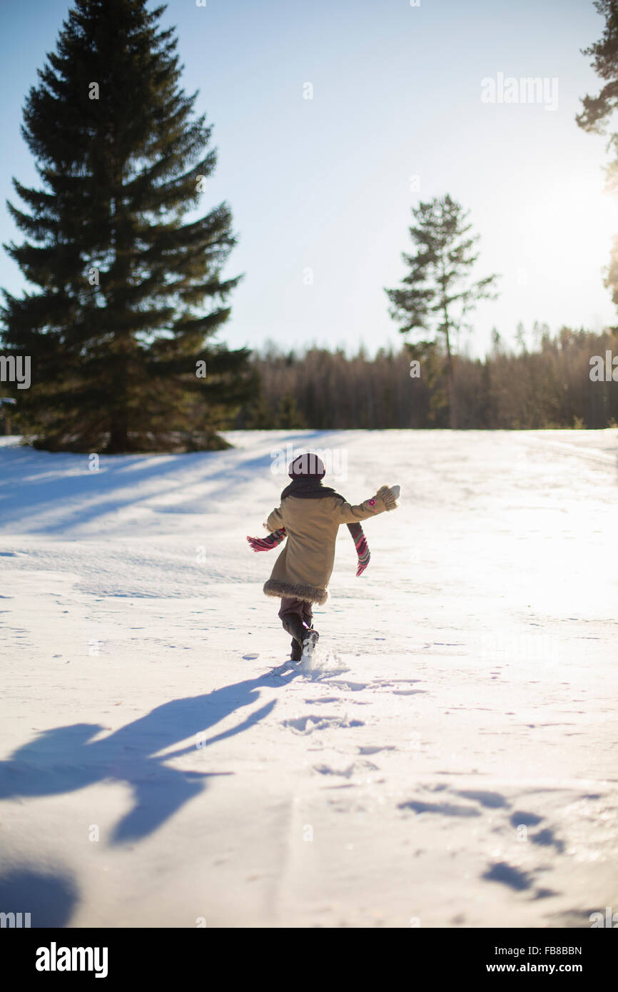 Sweden, Medelpad, Sundsvall, Girl (6-7) walking on snow on sunny day Stock Photo