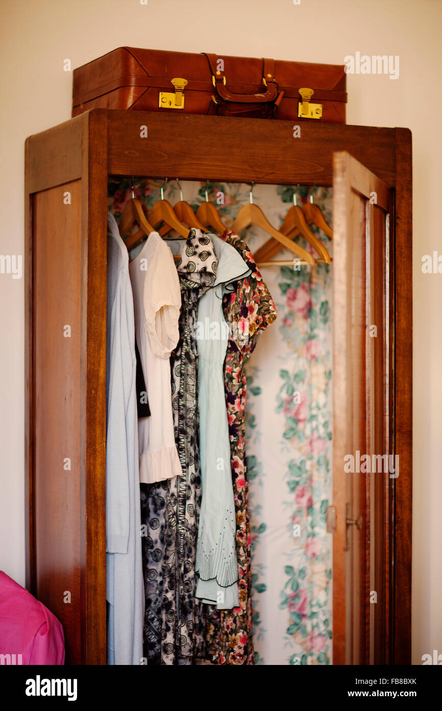Italy, Liguria, Imperia, Diano Marina, Clothes hanging in open wooden wardrobe Stock Photo