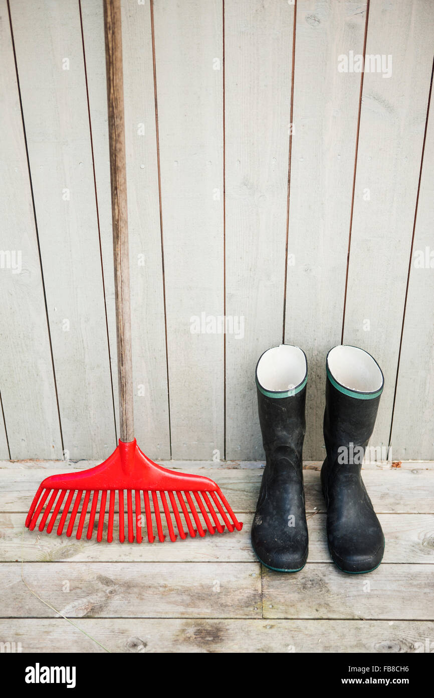 Sweden, Smaland, Hasselo, Rubber boots and rake Stock Photo - Alamy