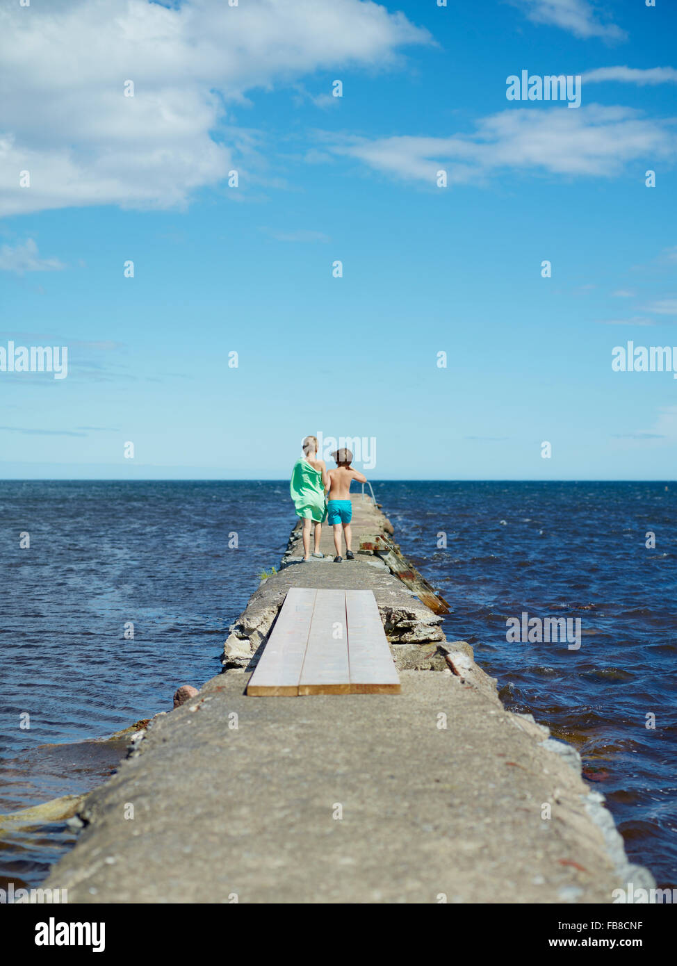 Sweden, Oland, Boys (6-7) walking on pier Stock Photo