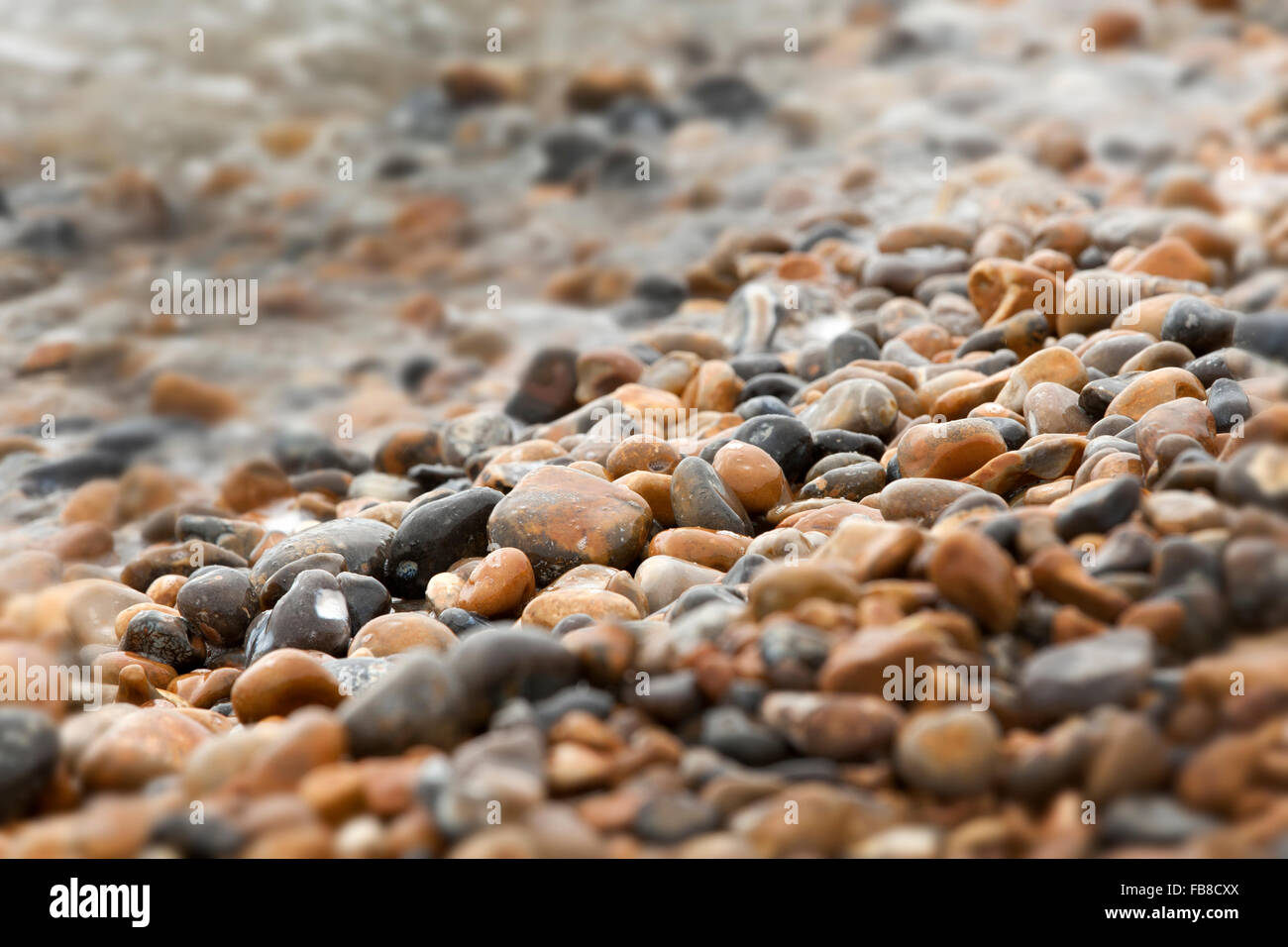 Sea washes over wet pebbles on British shingle coastline beach Stock ...