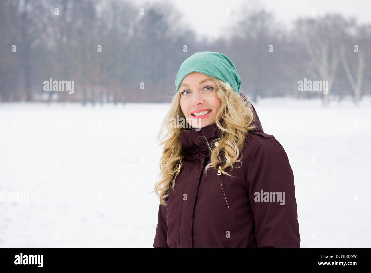woman walking on snowy field Stock Photo