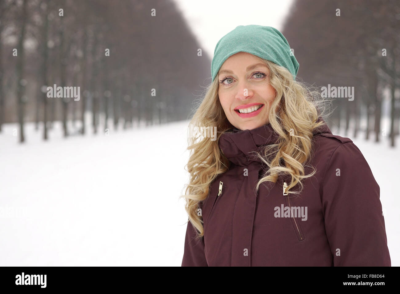 woman enjoying walk along snow covered alley Stock Photo