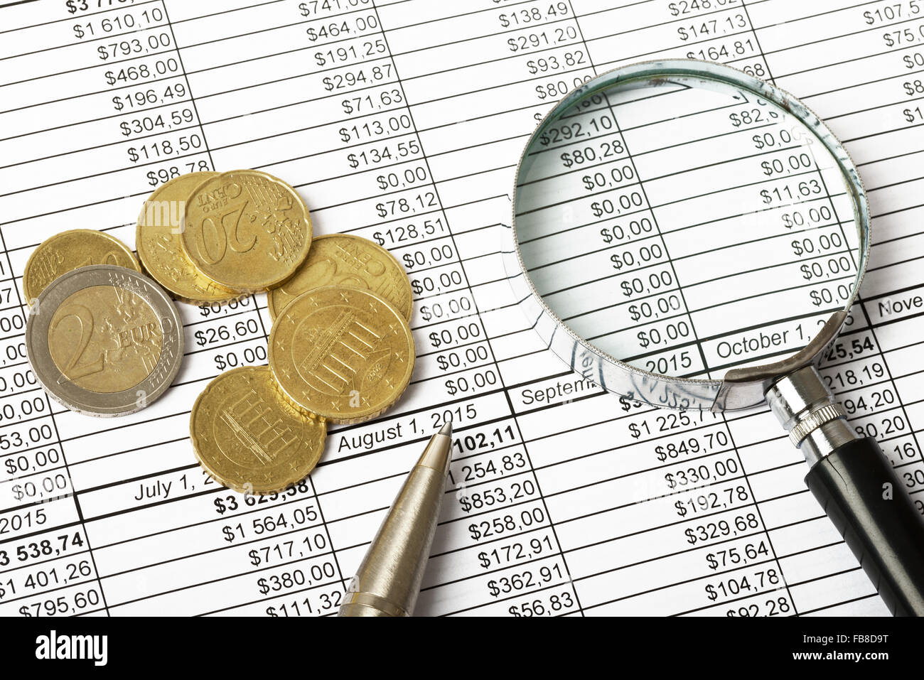 Magnifier with coins Stock Photo - Alamy
