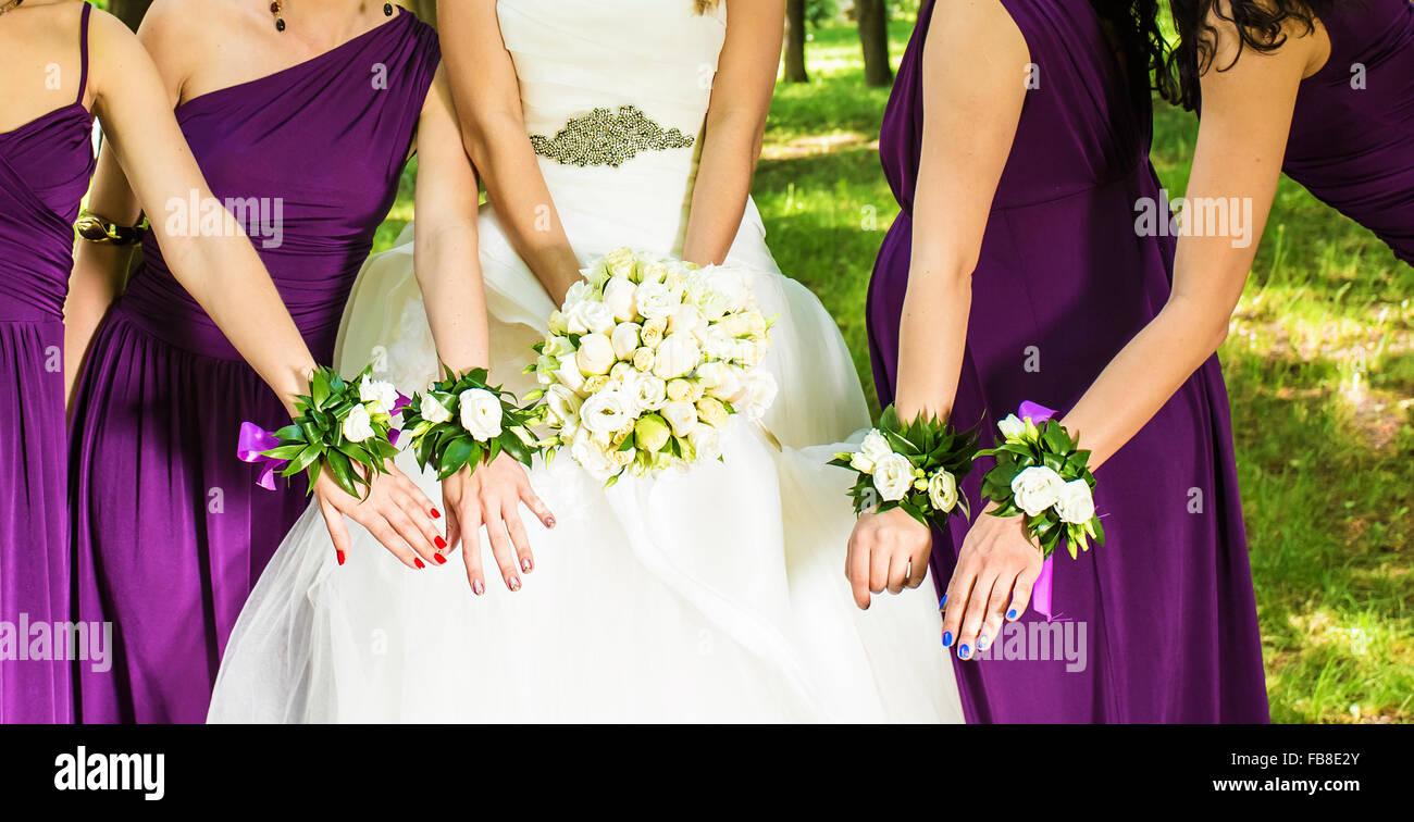 The bride and bridesmaids are showing beautiful flowers on their hands ...