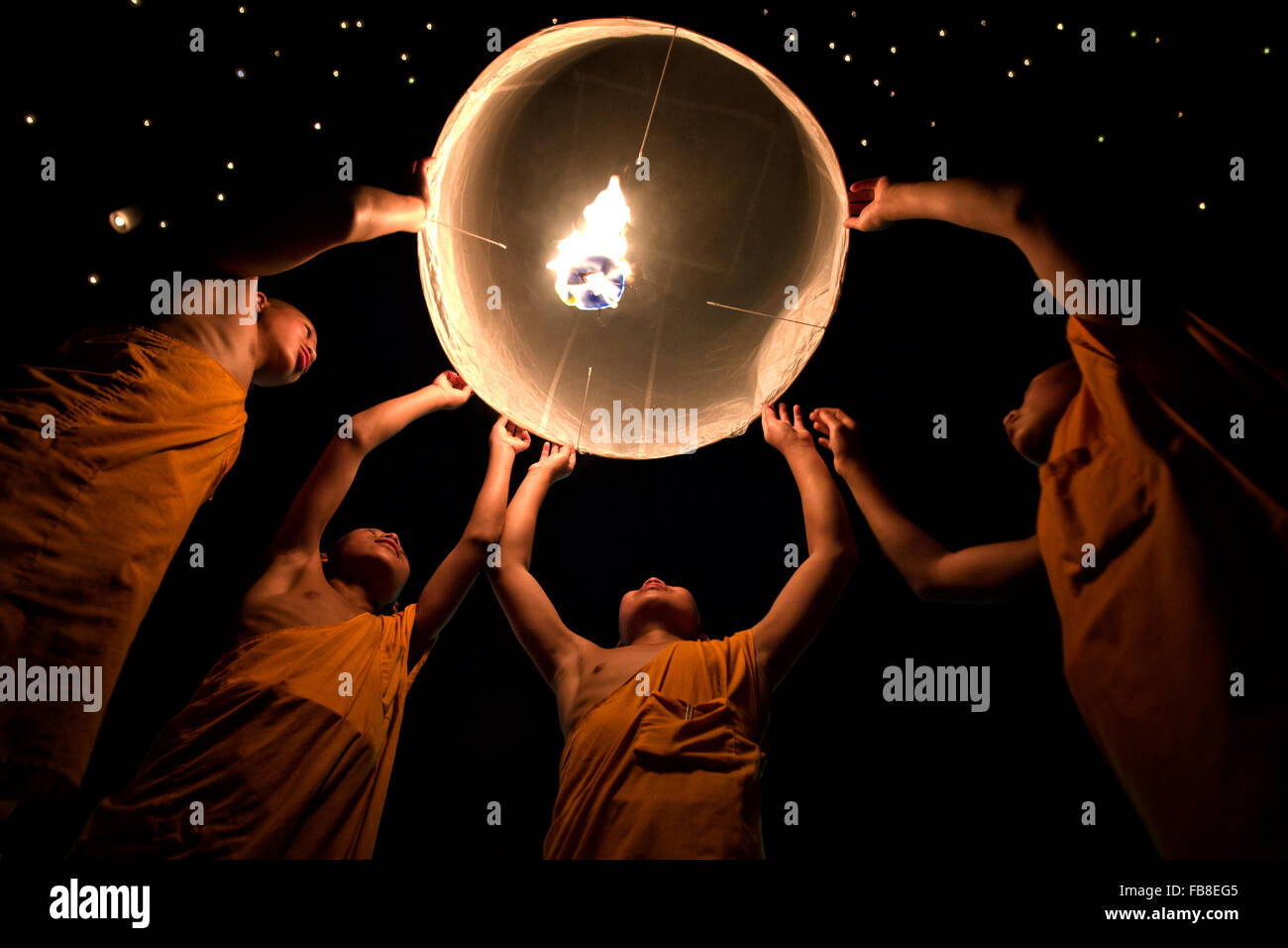 Monks holding a paper lantern at night during Loy Krathong festival in Chiang Mai, Thailand Stock Photo