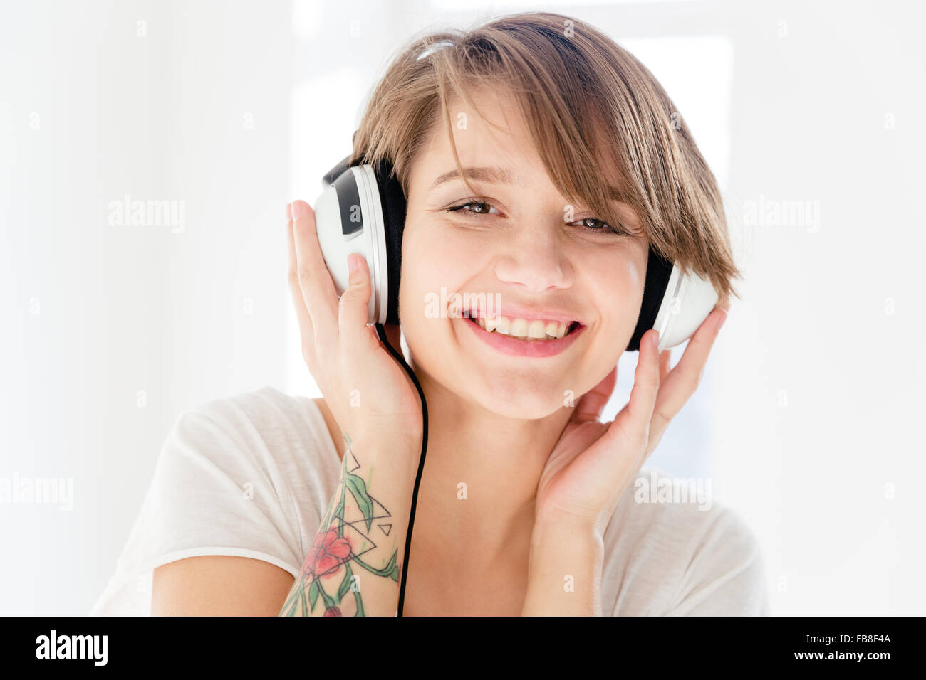 Closeup portrait of cheerful beautiful young woman in headphones ...