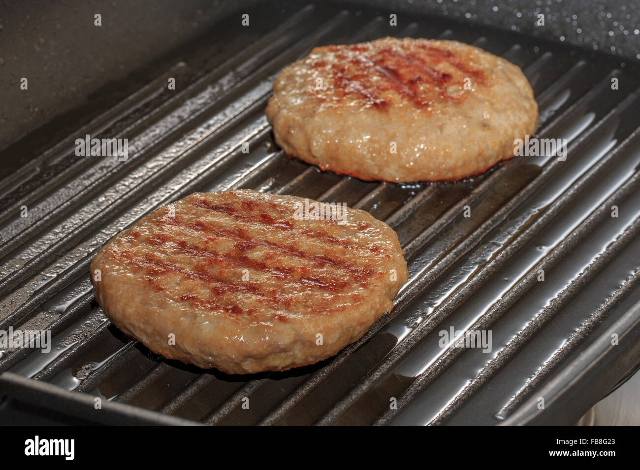 Burgers cooking in a griddle Stock Photo Alamy