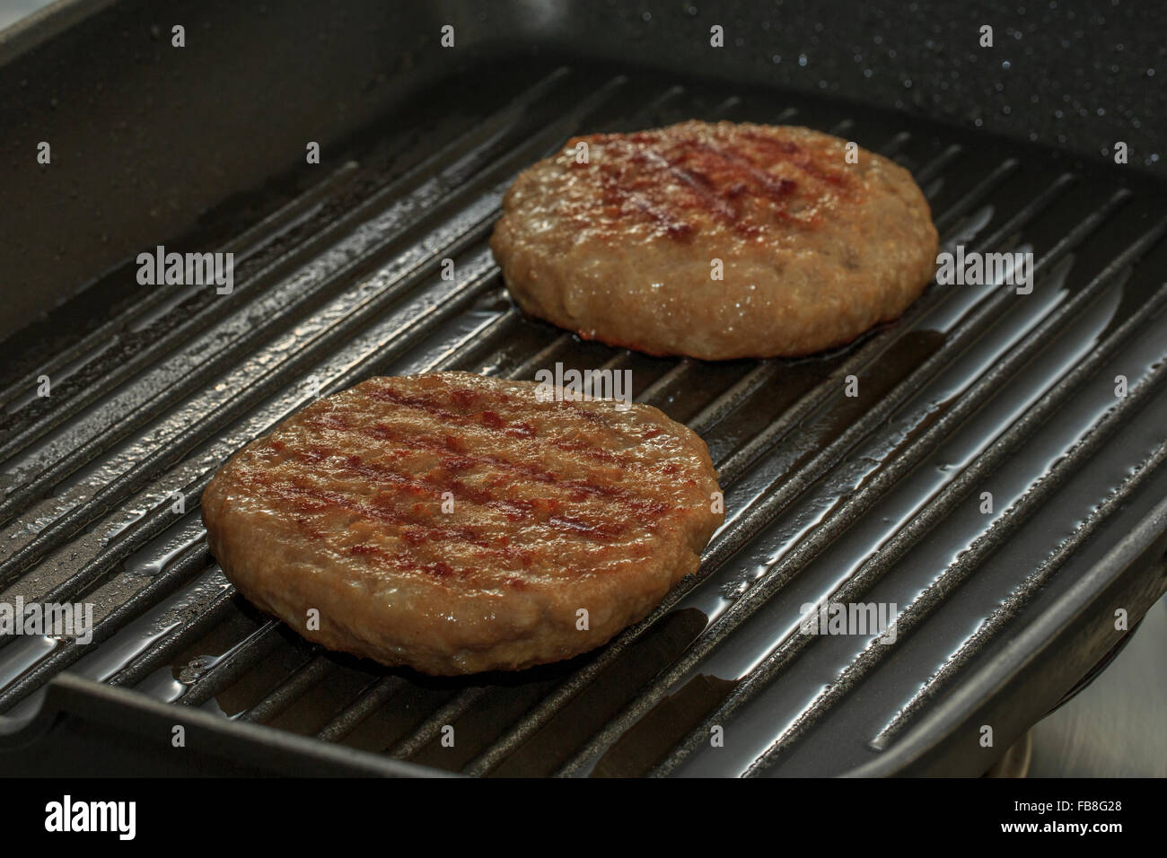 Burgers cooking in a griddle Stock Photo Alamy