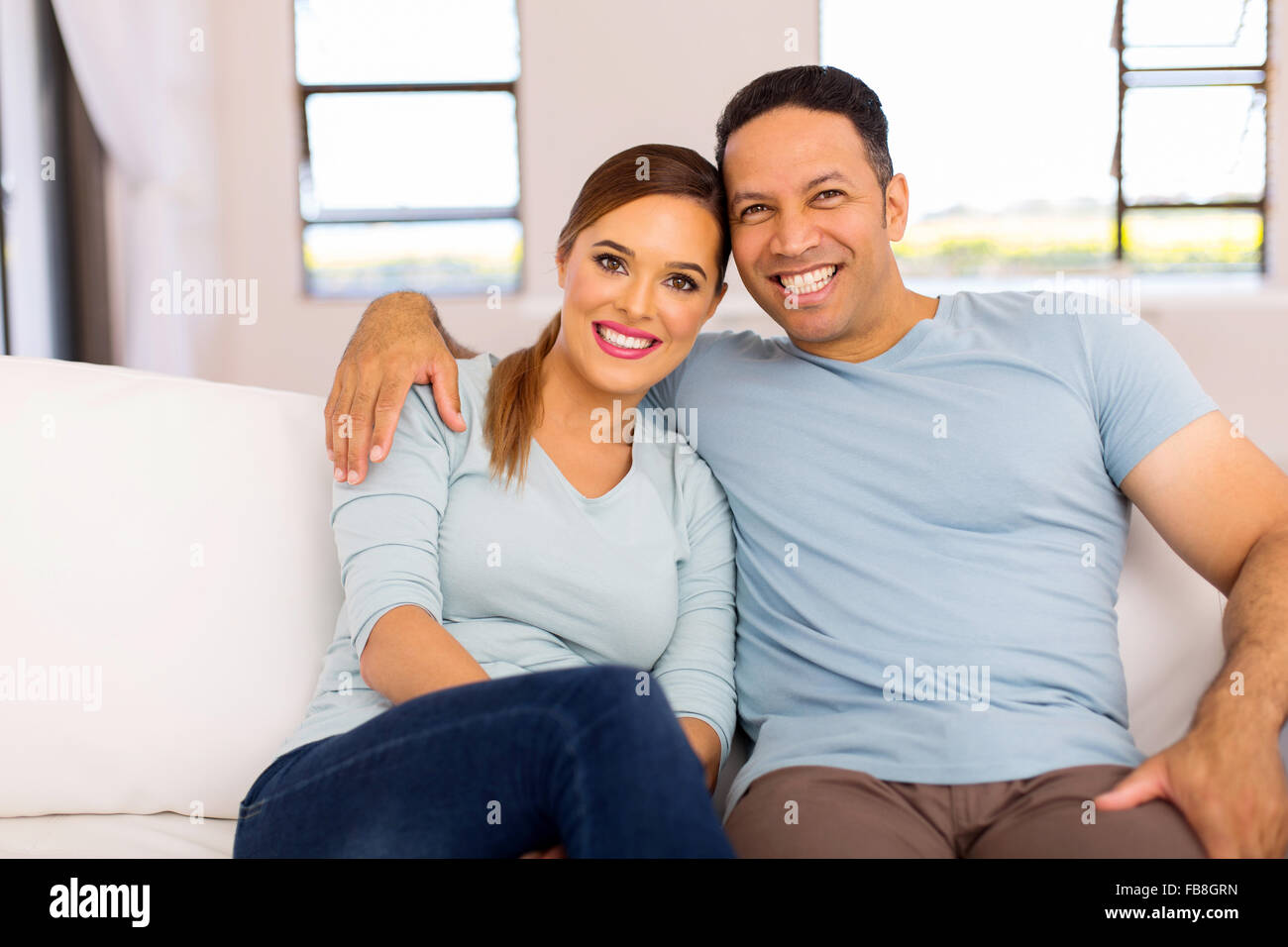 portrait of cute couple sitting on sofa at home Stock Photo